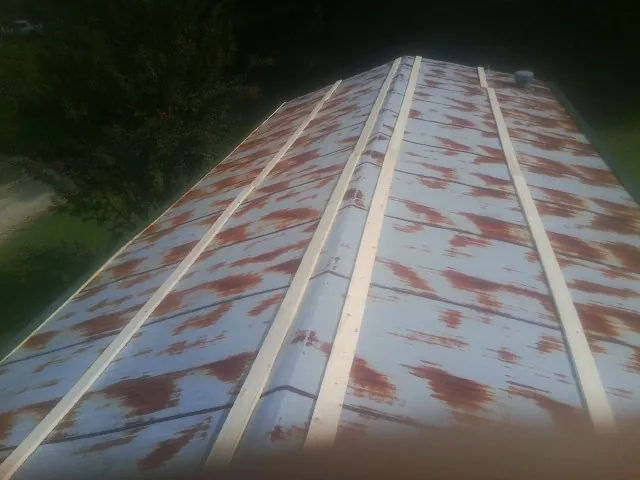 Rusted metal roof panels with new wood purlins before replacement — Storm Damage Roof Repair in Hay by Roofing Brothers