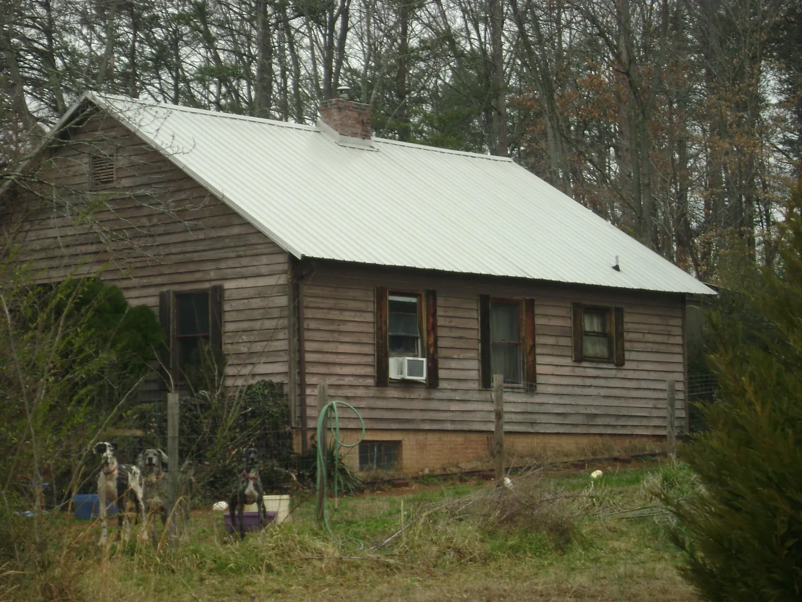 White metal roof on an old wood sided farmhouse, from a Metal Roof Installation job in Hay